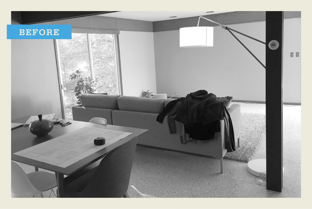 A black and white "before" photo showing a living room with a sofa, table and chairs, and a lamp.