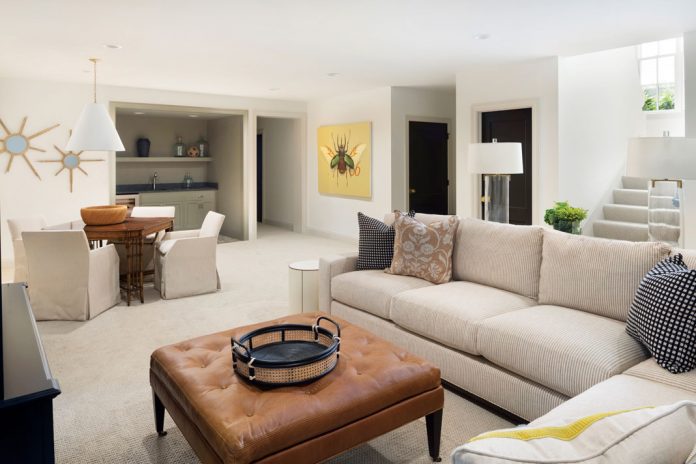 The lower level of a home on Midwest Home's 2018 Luxury Home Tour that features a large sofa next a brown table.