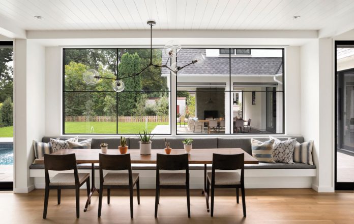 A kitchen in a home on Midwest Home's 2018 Luxury Home Tour with table and chairs that overlooks the home's pool.