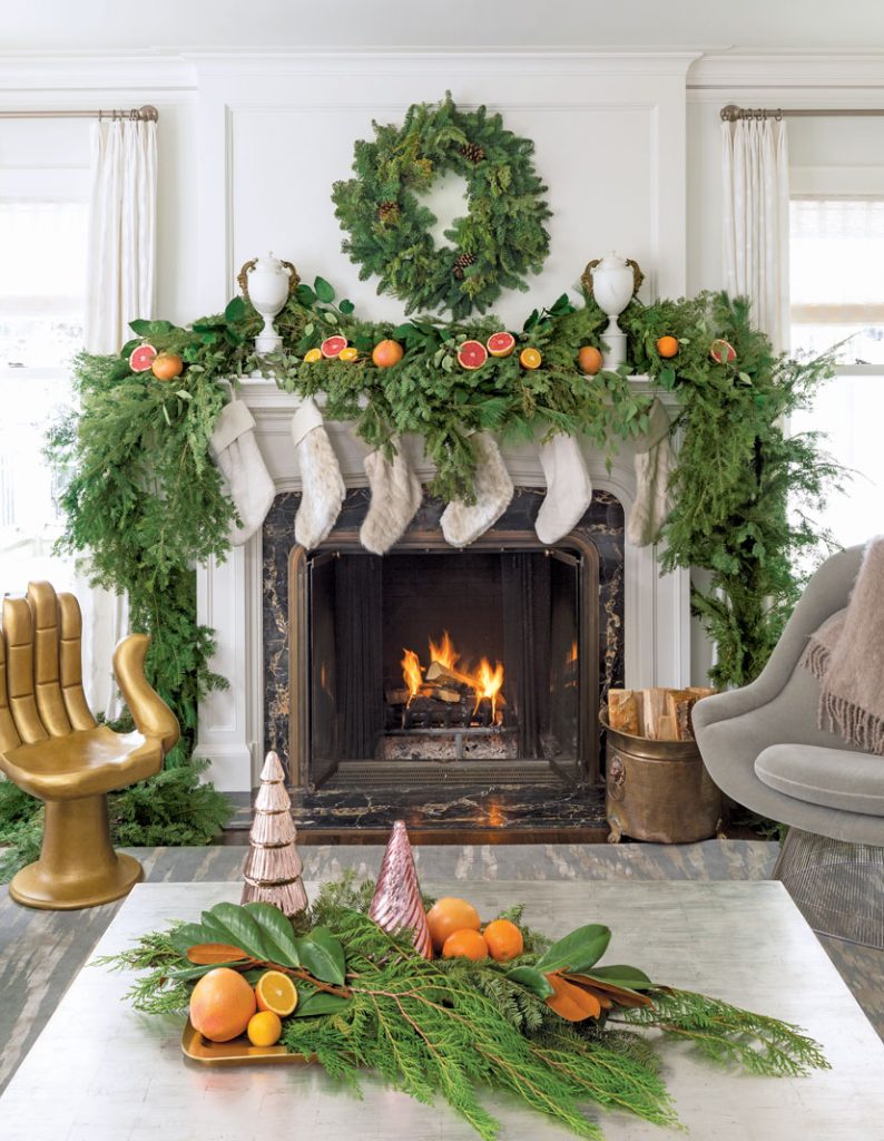 Fresh evergreens, citrus, and faux fur stockings decorate the period fireplace, capturing the spirit of the season and the expert blend of old and new in the stately 1920s Georgian.