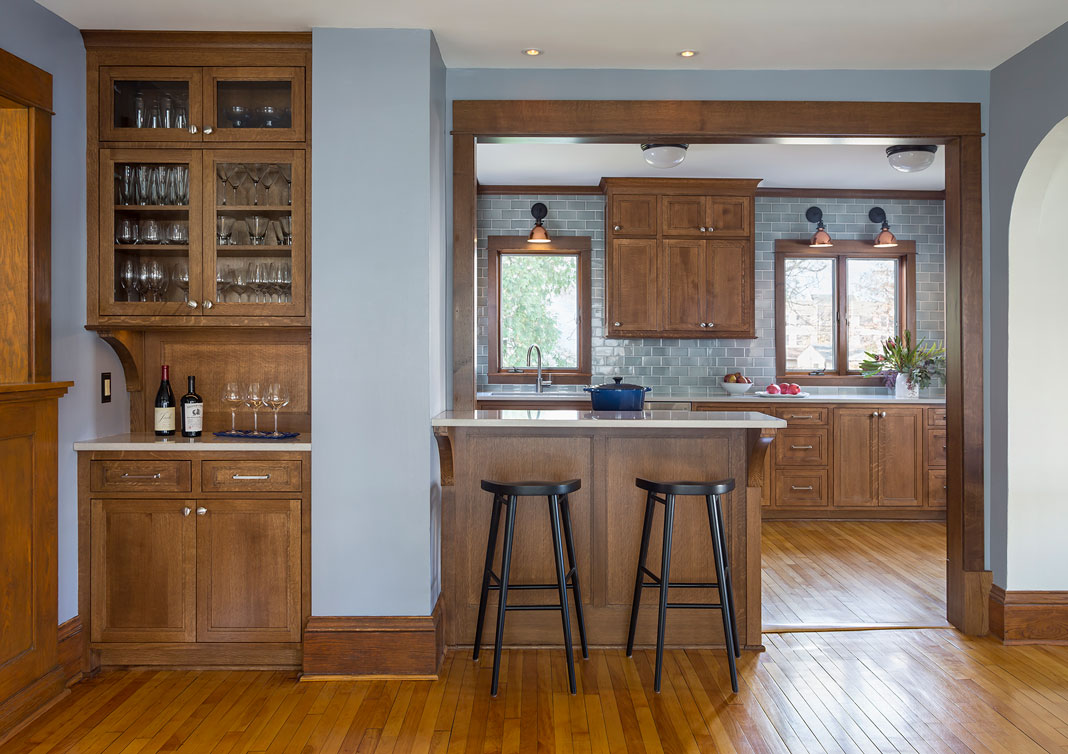 A kitchen with gray blue Sonoma tiles, eat-in counter, sconces, and more.