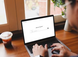 5 Ways Design Professionals Can Use AI erson browsing ChatGPT 4.5 homepage on MacBook Pro in cafe with iced black coffee beside window