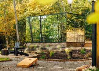 Mirror cabin in Crosby, Minnesota, reflects the surrounding forest during the daytime.
