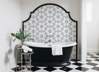 A bathroom with elegant tiling details, in bold black and white
