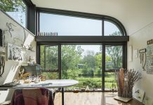An art studio inside a home with large windows that look out to the creek.