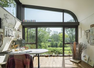 An art studio inside a home with large windows that look out to the creek.