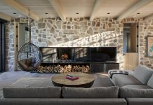 This wood-burning fireplace in a Cross Lake home is surrounded by a horizontal, built-in blackened steel framework and stone.