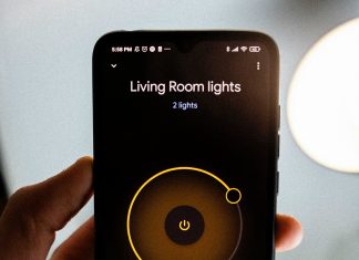 Person holding iPhone showing an app that can control living room light brightness
