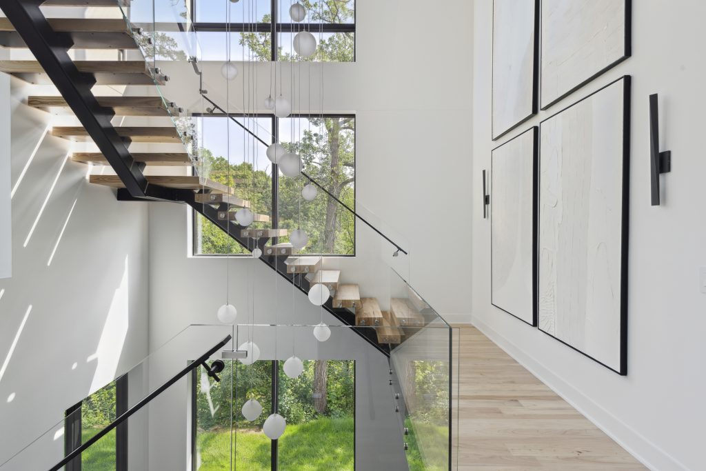 Large windows, a winding staircase, and local Hennepin Made lighting fixtures are on display in this sustainable home from Sustainable 9 + Design and Unfold Architecture
