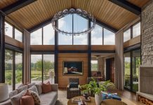 The great room of this Orono home features floor-to-ceiling windows and natural, inviting elements.