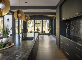 This kitchen features clean lines, a neutral palette, and bold light fixtures.