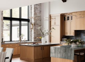 The chef’s-style kitchen features a spacious pantry and dual islands topped with quartzite, one with a unique half-waterfall countertop.