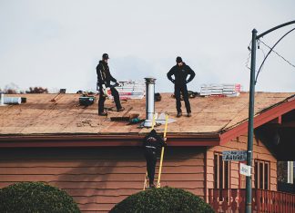 Men working to repair house roof