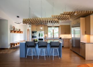 This ceiling structure brings warmth and artful function to this expansive, vaulted kitchen.