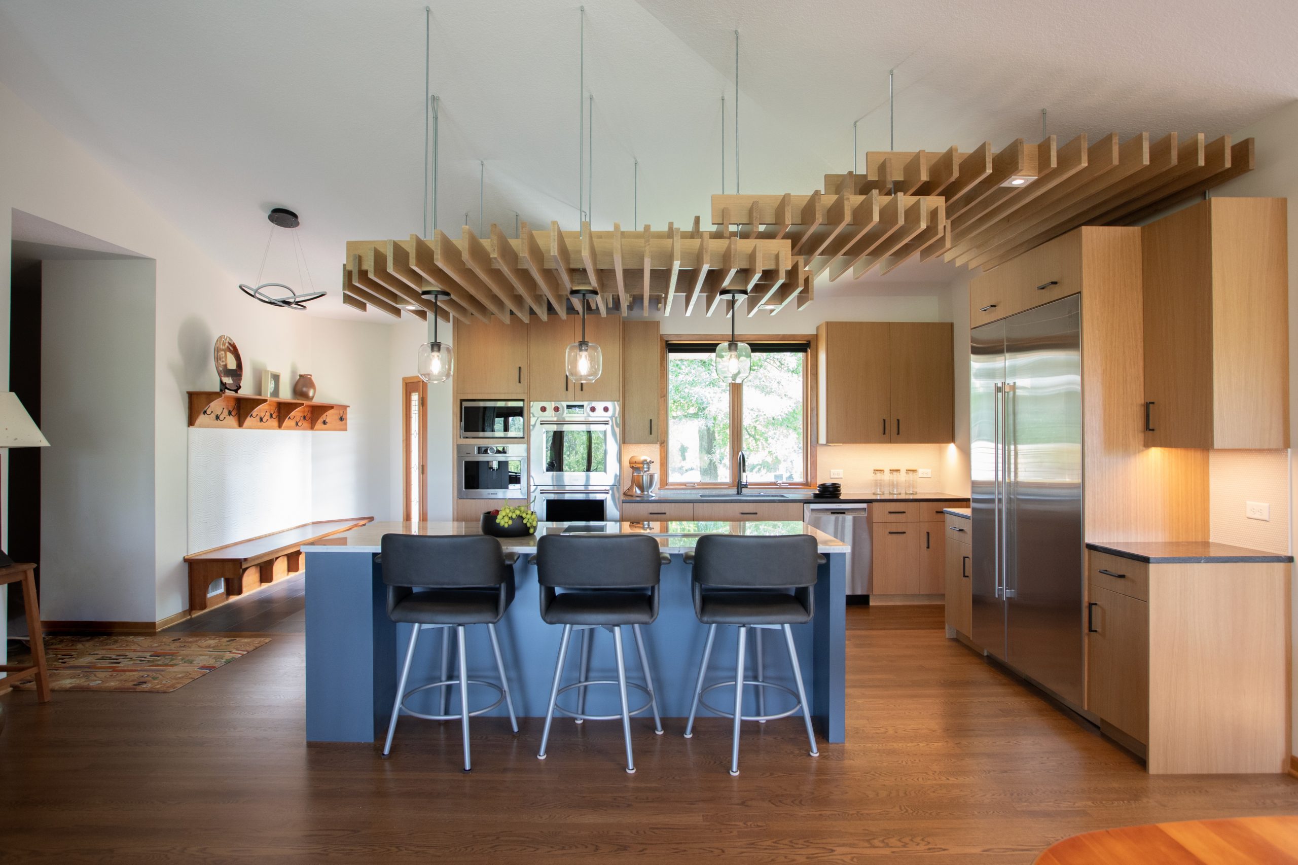 This ceiling structure brings warmth and artful function to this expansive, vaulted kitchen.